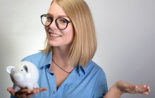 young pretty woman presenting piggy bank